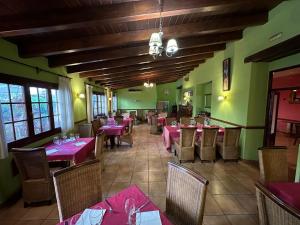 a restaurant with tables and chairs with pink tablecloths at Hotel De La Villa in Rubielos de Mora