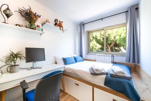 a bedroom with a bed and a desk and a window at Résidence méditerranée - Beachfront - Sun and Seaview - Pool - Private Parking in Cagnes-sur-Mer