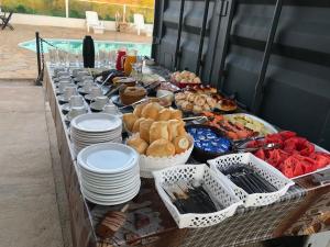 a buffet of food on a table with plates at ROYAL CONTAINER HOTEL in Capitólio