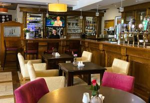 un restaurante con mesas y sillas y un bar en Hannon's Hotel, en Roscommon