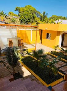 a yellow house with a table and chairs in a courtyard at Villa Myakatra in Hell-Ville