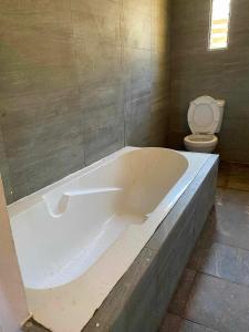 a bath tub in a bathroom with a toilet at Villa Myakatra in Hell-Ville