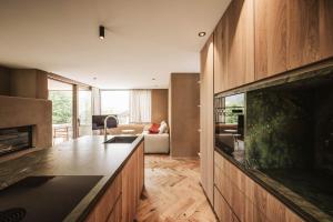 a kitchen with a counter and a living room at Milla Apartments in Bressanone