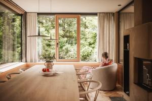 a woman sitting in a chair in a room with a table at Milla Apartments in Bressanone