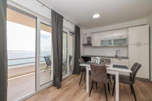 a kitchen and dining room with a view of the ocean at Beachfront Apartments Tić with Seaview in Miletići