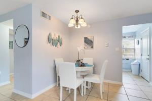 a dining room with a white table and chairs at Ocean 8 - Seashell in Indian Harbour Beach +33 photos