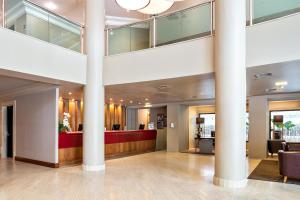 a lobby with columns and a reception desk in a building at Tabas - Melia Confort in São Paulo