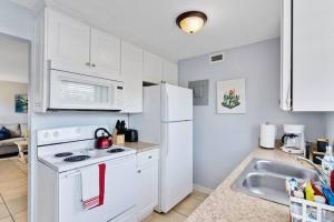 een keuken met een witte koelkast en een wastafel bij Beachside 8 in Indian Harbour Beach