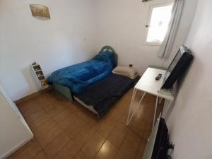 Habitación pequeña con cama y mesa en Lollapalooza muy cerca en San Isidro