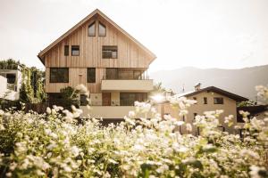 a house seen from the garden with flowers at Milla Apartments in Bressanone