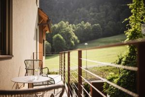 een tafel en stoel op een balkon met uitzicht op een veld bij Milla Apartments in Bressanone