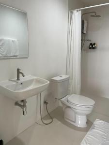a white bathroom with a sink and a toilet at GO INN HuaHin โกอินน์ หัวหิน in Hua Hin