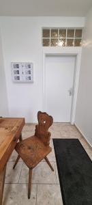 a wooden chair sitting in a room with a door at FeWo zur alten Tischlerei in Herzberg am Harz
