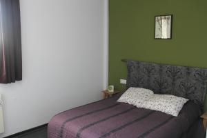 sypialnia z łóżkiem z fioletowym kocem w obiekcie Casitas El Paraje de Berchules w mieście Bérchules
