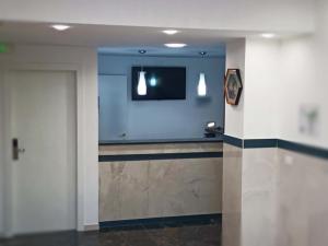 um quarto com uma televisão e um corredor com uma porta em ANMAN HHBB tourism & business rooms em Pádua