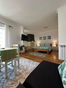 a living room with a bed and a table at Comfortable and quiet apartment in Nazaré