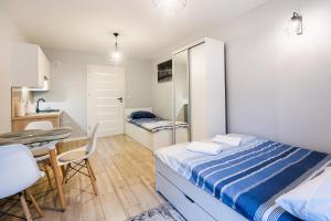 sypialnia z łóżkiem i stołem oraz kuchnia w obiekcie Apartamenty,pokoje Paholski w Zubrzycy Górnej