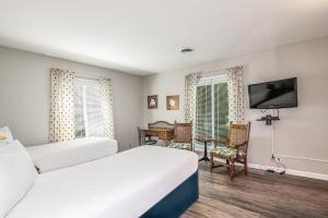 ein Hotelzimmer mit zwei Betten und einem Flachbildfernseher in der Unterkunft Litchfield Country Club Cottage 4BR 4BA Retreat in Pawleys Island