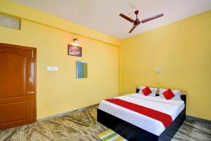 - une chambre avec un lit et un ventilateur de plafond dans l'établissement OYO Flagship Hotel Elite Inn, à Bhubaneswar