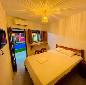 1 dormitorio con cama grande y luz en Pousada Ventos e Velas, en Porto de Pedras