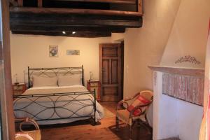 1 dormitorio con 1 cama y chimenea en La Collina dei Passeri en Pocapaglia