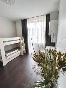 a bedroom with a bed and a table with a plant at Riga Modern Apartment in Rīga