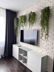 un soggiorno con TV su un muro di mattoni di Riga Modern Apartment a Riga