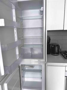 an empty refrigerator with its door open in a kitchen at Riga Modern Apartment in Rīga