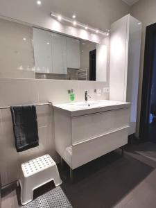 a white bathroom with a sink and a mirror at Riga Modern Apartment in Rīga