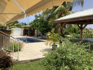 a backyard with a swimming pool and a patio at VILLA ALIZEE APPARTEMENT 2 in Sainte-Rose