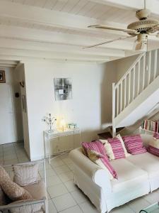 uma sala de estar com um sofá branco e uma escada em Appartement T3 vue mer sur ilet Gosier em Le Gosier