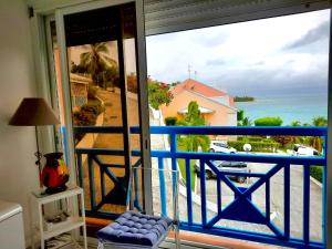 um quarto com uma varanda com vista para o oceano em Appartement T3 vue mer sur ilet Gosier em Le Gosier
