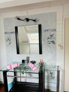 uma casa de banho com uma mesa de vidro e um espelho em Appartement T3 vue mer sur ilet Gosier em Le Gosier