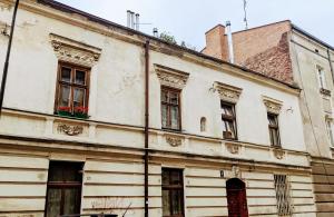 um antigo edifício branco com janelas e um telhado em ViP Apartment Krakow na Cracóvia