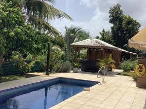 a swimming pool in a yard with a gazebo at VILLA ALIZEE APPARTEMENT 2 in Sainte-Rose