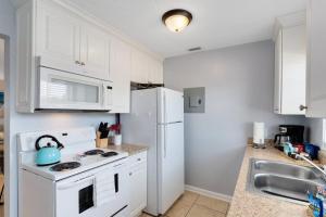 a kitchen with white appliances and a white refrigerator at Ocean 16 - Pier View in Indian Harbour Beach