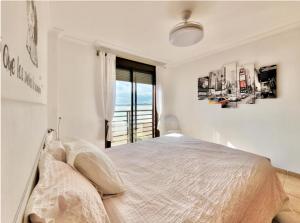a white bedroom with a bed and a window at Sunny Home La Tejita in Granadilla de Abona