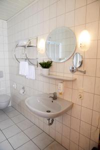 a bathroom with a sink and a mirror at Gästehaus am Landhaus Friedrichsfehn in Edewecht