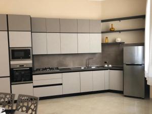 a kitchen with white cabinets and a stainless steel refrigerator at Palazzo Galzerano in Moio della Civitella