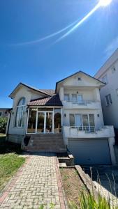 a large white house with a driveway and stairs at Prishtina rental house in Prishtinë