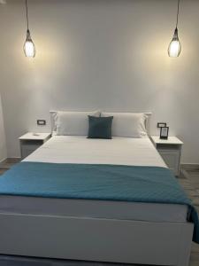 1 dormitorio con 1 cama blanca y 2 mesitas de noche en ANMAN HHBB tourism & business rooms, en Padua