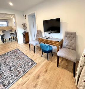 a living room with a desk and chairs and a tv at Gastuna Suites-Familienapartment in Bad Hofgastein