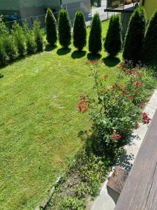 a garden with a row of trees and flowers at Gastuna Suites-Familienapartment in Bad Hofgastein