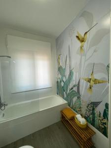 Villa Paraiso في Cazalegas: حمام مع حوض استحمام وجدارية للطيور