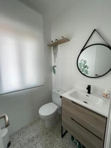 a bathroom with a toilet and a sink and a mirror at Villa Paraiso in Cazalegas