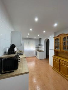 una cucina con pareti bianche, armadi in legno e bancone di Villa Paraiso a Cazalegas