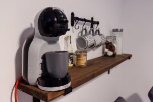 a coffee maker sitting on a wooden shelf at comfortable 4 bedroom house in Aylesbury ideal for contractors, proffesionals or bigger family in Aylesbury