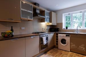 a kitchen with a washing machine and a washer at Comfortable 4-Bedroom Home in Aylesbury Ideal for Contractors Professionals or Larger Families in Aylesbury
