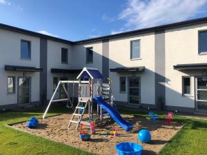 un parque infantil frente a un edificio en Domki Wypoczynkowe "Sea Breeze", en Rewal