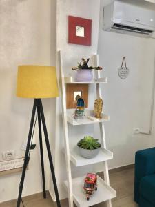 a white shelving unit with a lamp in a living room at Lola’s Apartment in Durrës